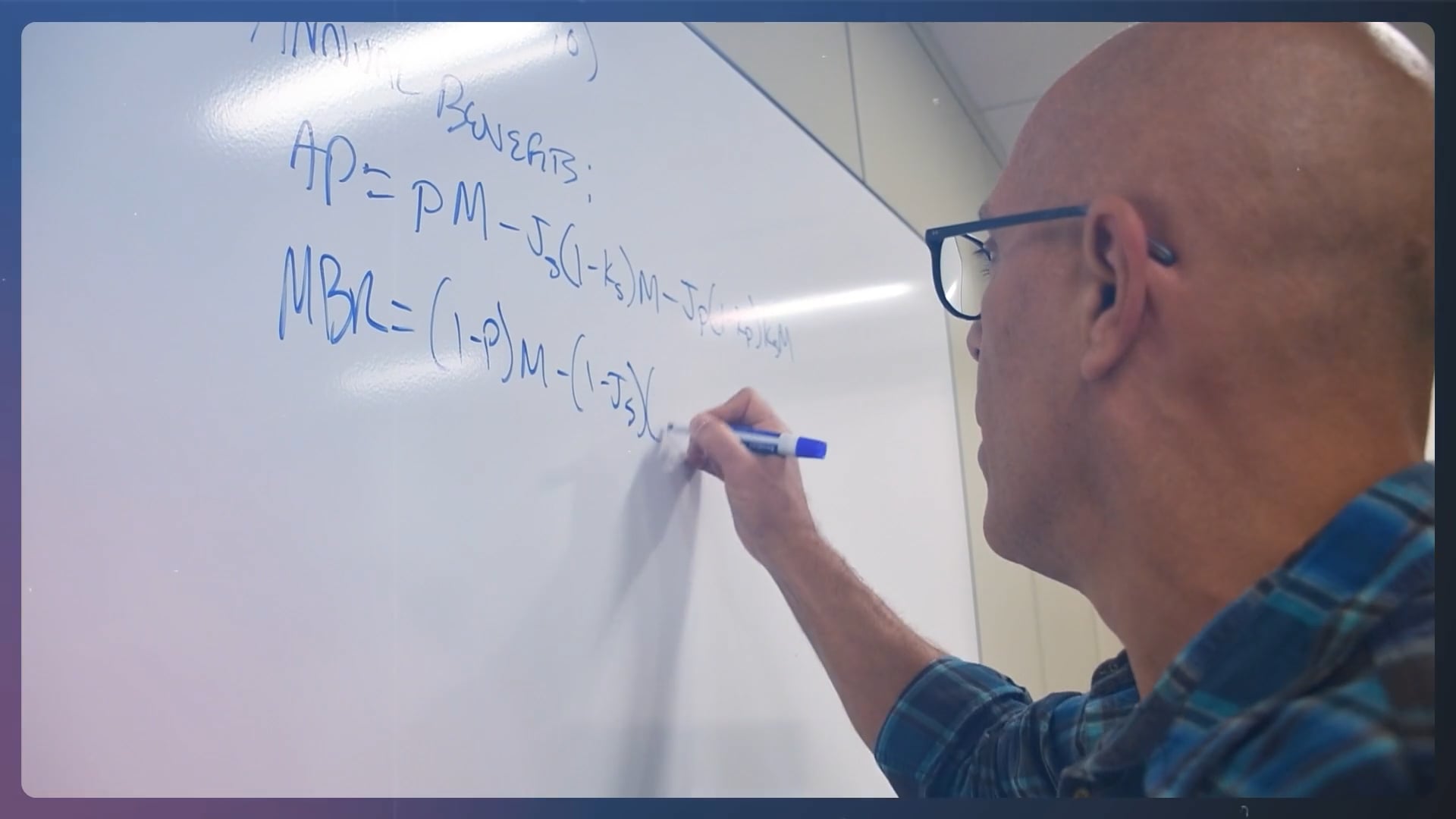 A NYSTRS staff member writes an Annual Benefits equation on on a dry erase board.